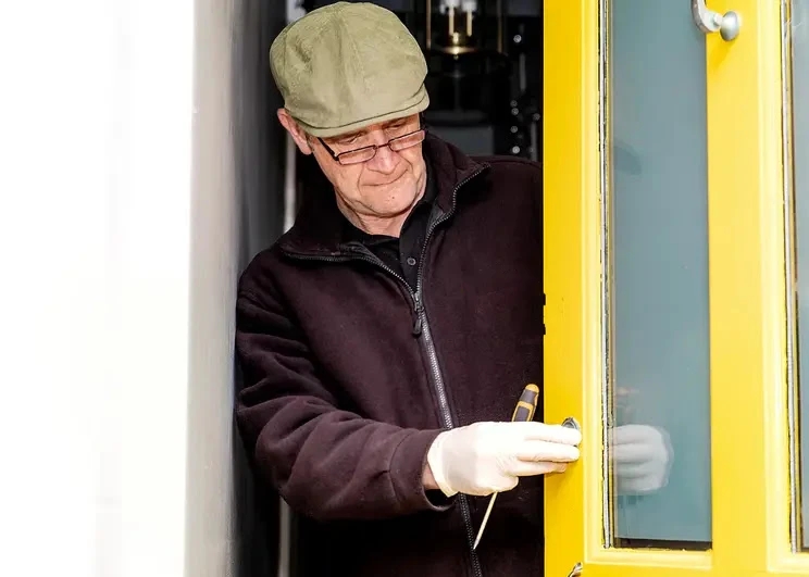 Jeffrey Seymour inspecting a yellow door